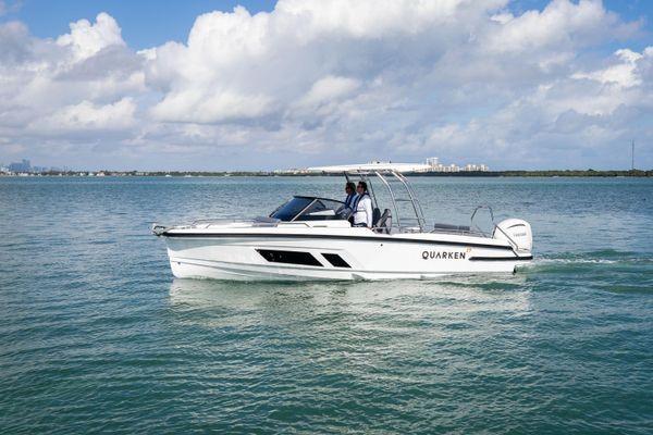 Slide: The Image of 2024 Quarken 27 T-Top V2 boat cruising on a calm sea under a partly cloudy sky. - 6