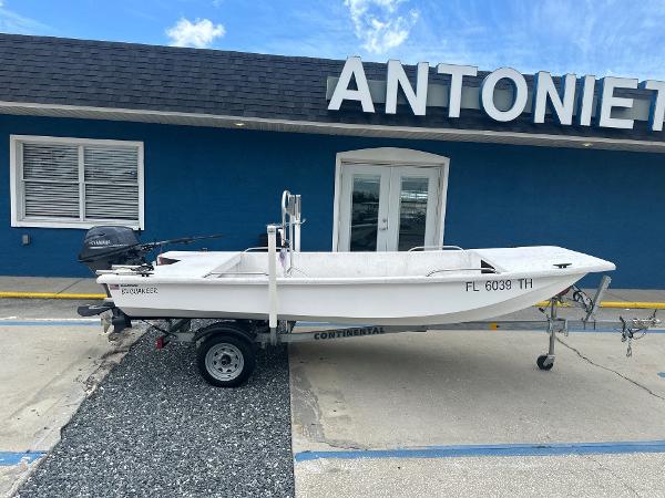 Slide: The Image of 2023 Rabco Buccaneer 14 skiff on trailer, parked outside a blue building. - 1