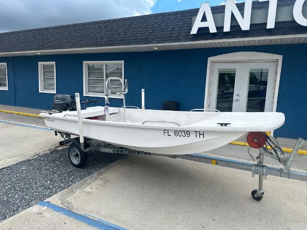 Slide: The Image of 2023 Rabco Buccaneer 14 skiff on trailer outside blue building. - 2