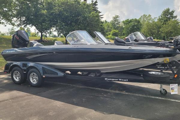 Slide: The Image of 2023 Ranger 212LS boat on a trailer in a parking lot. - 0