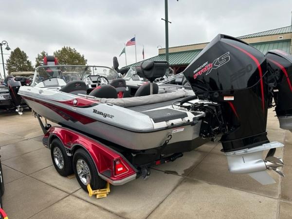 Slide: The Image of 2023 Ranger 212LS boat with powerful engine on display at a dealership. - 2