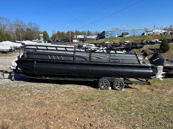 Slide: The Image of 2023 Ranger 2500LS pontoon boat on a trailer in a boatyard. - 1