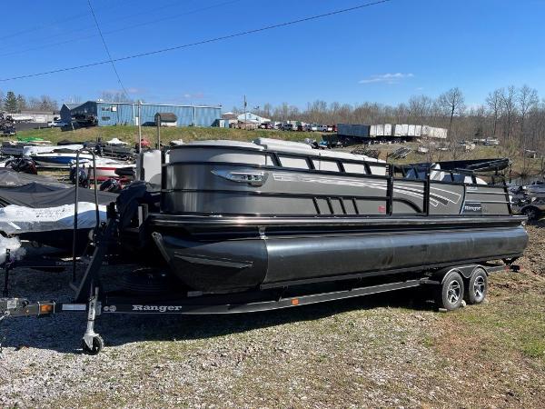 Slide: The Image of 2023 Ranger 2500LS pontoon boat on a trailer in an outdoor lot. - 2