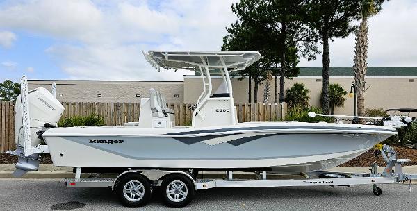 Slide: The Image of 2024 Ranger 2600 Bay boat on trailer, side view, white hull, outdoor setting. - 0