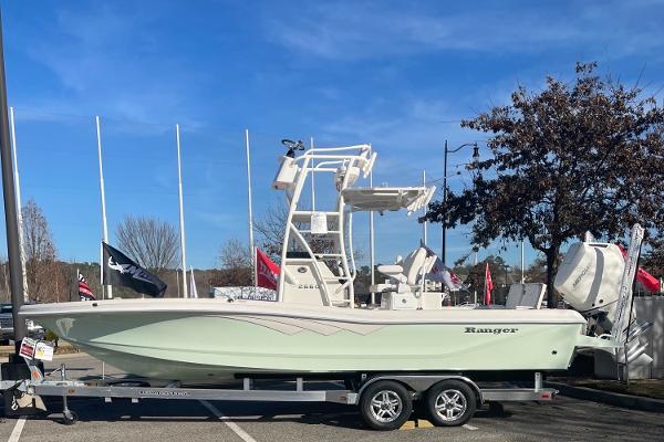 Slide: The Image of 2024 Ranger 2660 Bay boat on a trailer in a parking lot. - 0