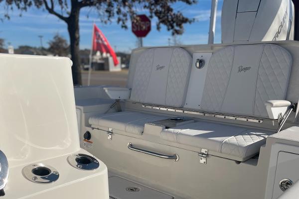 Slide: The Image of 2024 Ranger 2660 Bay boat interior with white seating and cup holders. - 2
