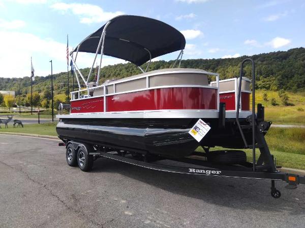 Slide: The Image of 2024 Ranger Reata 200C pontoon boat on trailer, red and white, parked outdoors. - 0