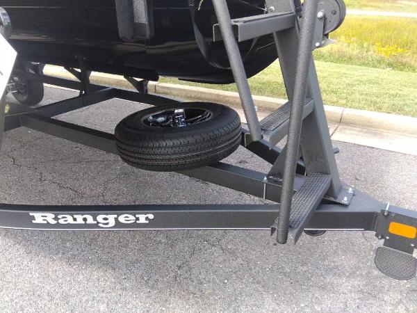 Slide: The Image of 2024 Ranger Reata 200C boat trailer with spare tire on asphalt. - 7