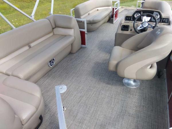 Slide: The Image of 2024 Ranger Reata 200C pontoon boat interior with beige seating and modern dashboard. - 8