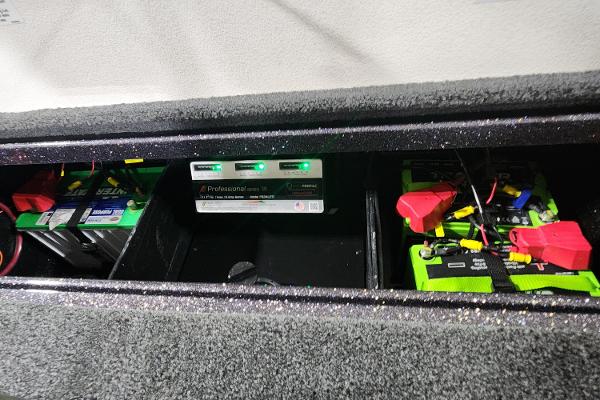 Slide: The Image of 2024 Ranger Z518 boat battery compartment with charger and wiring. - 13