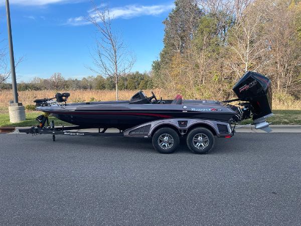 Slide: The Image of 2024 Ranger Z519 boat on trailer, parked on a road with trees in the background. - 0