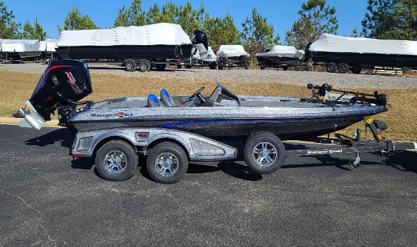 Slide: The Image of 2024 Ranger Z519 boat on trailer, parked outdoors, with trees in the background. - 1
