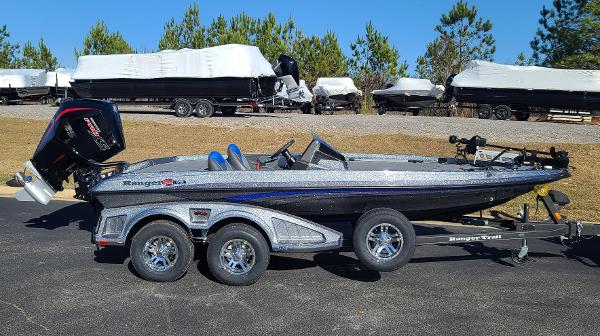 Slide: The Image of 2024 Ranger Z519 boat on trailer, parked outdoors with covered boats in background. - 2