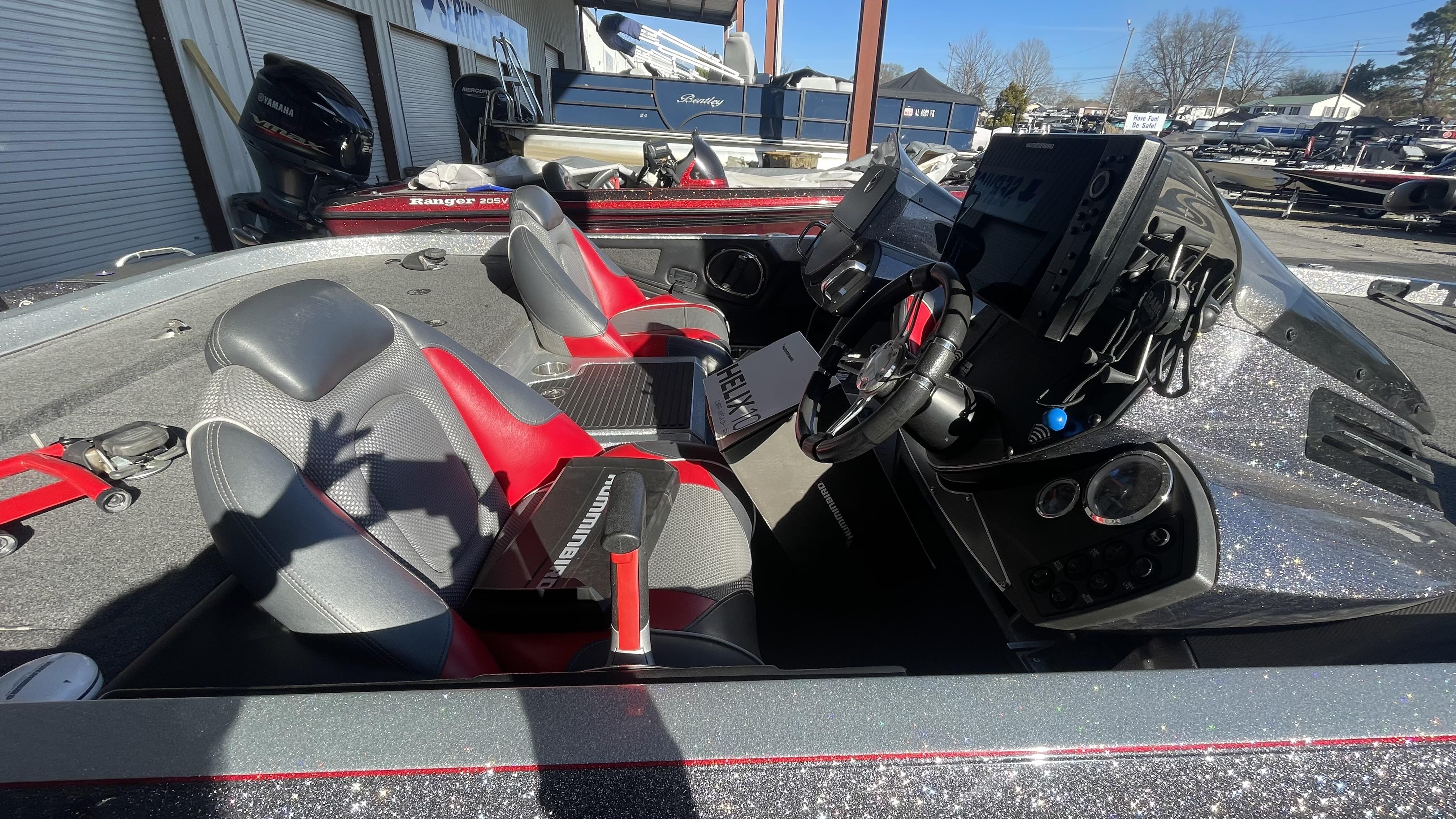 Slide: The Image of 2018 Ranger Z519C boat interior with red and gray seats, steering wheel, and control panel. - 18