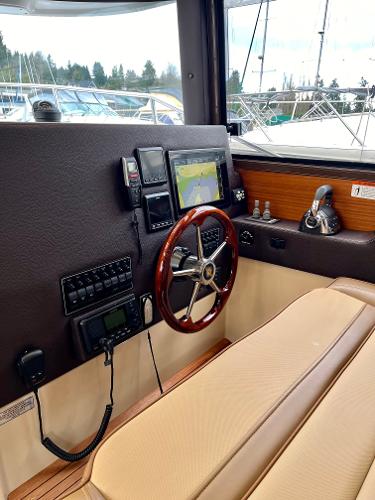 Slide: The Image of 2019 Ranger Tugs R-29S helm with navigation system and wooden steering wheel. - 2