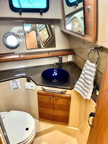 Slide: The Image of 2019 Ranger Tugs R-29S bathroom with modern sink and wooden cabinetry. - 4