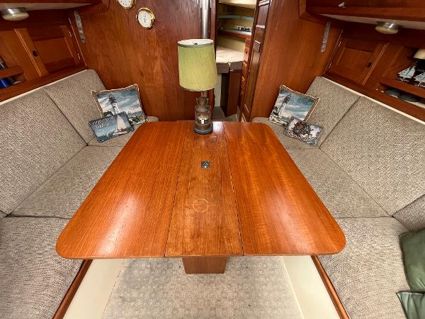 Slide: The Image of 1979 Ranger Yachts 30 interior dining area with wooden table and cushioned seating. - 22