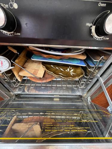 Slide: The Image of 1979 Ranger Yachts 30 oven with dishes and kitchenware inside. - 25