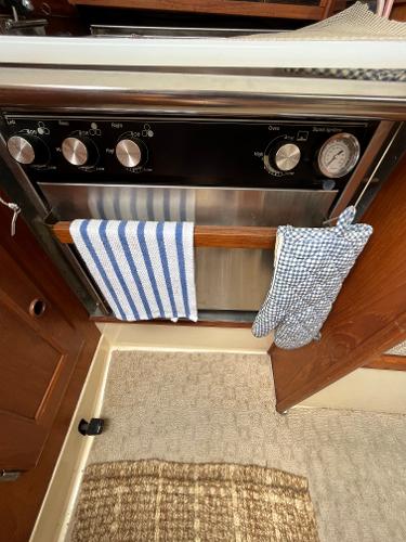 Slide: The Image of 1979 Ranger Yachts 30 kitchen oven with striped towel and checkered oven mitt. - 27
