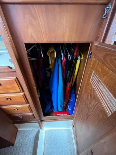 Slide: The Image of Wooden closet in a 1979 Ranger Yachts 30, filled with hanging clothes. - 32