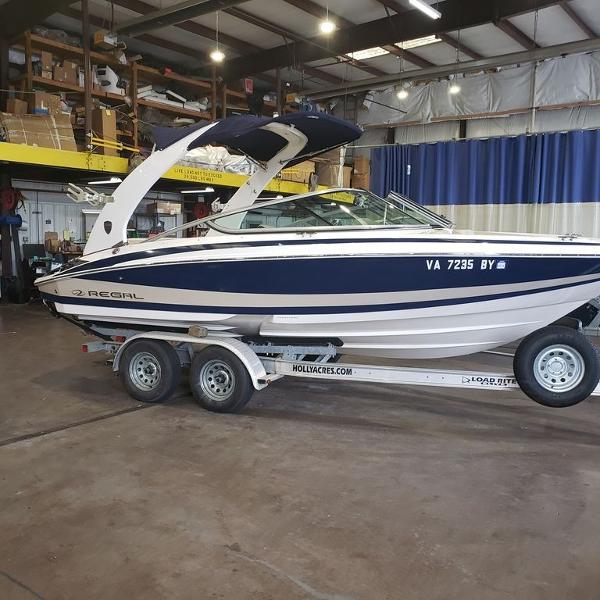 Slide: The Image of 2014 Regal 2100 boat on trailer in indoor storage facility. - 0