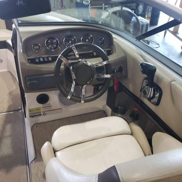 Slide: The Image of Interior cockpit of a 2014 Regal 2100 boat with steering wheel and control panel. - 2