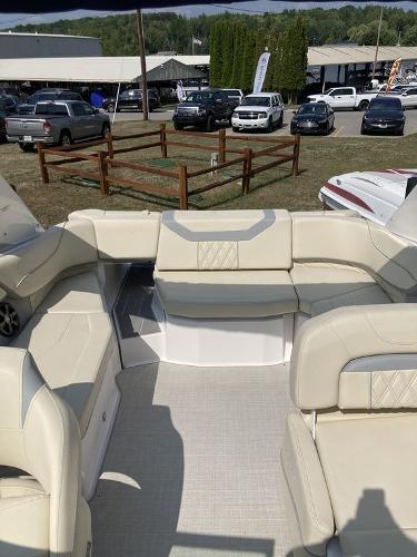 Slide: The Image of 2022 Regal 22 FasDeck boat interior with beige seating, parked outdoors. - 3