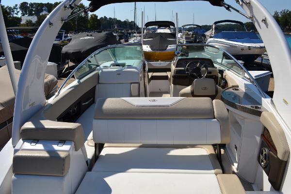 Slide: The Image of 2013 Regal 24 FasDeck boat interior with seating and steering wheel, docked at marina. - 14