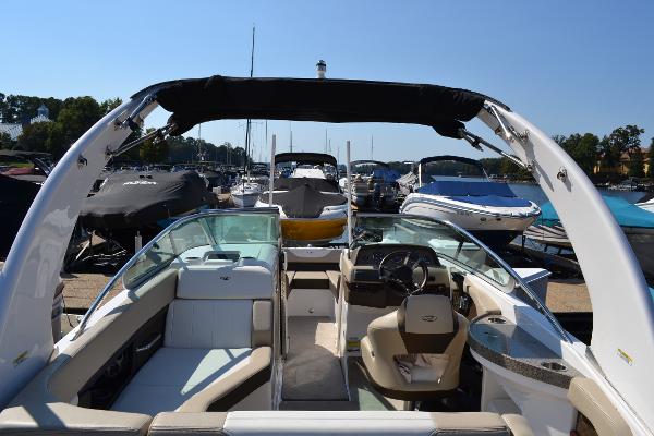 Slide: The Image of 2013 Regal 24 FasDeck boat interior at marina, featuring seating and steering console. - 17