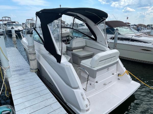 Slide: The Image of 2021 Regal 26 Express boat docked at marina with black canopy. - 1