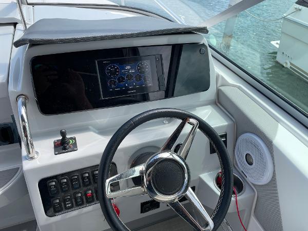 Slide: The Image of 2021 Regal 26 Express boat dashboard with steering wheel and digital display. - 12