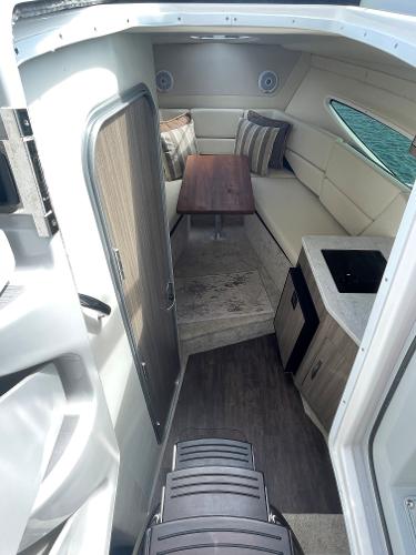 Slide: The Image of Interior of 2021 Regal 26 Express boat with seating, table, and kitchenette. - 14