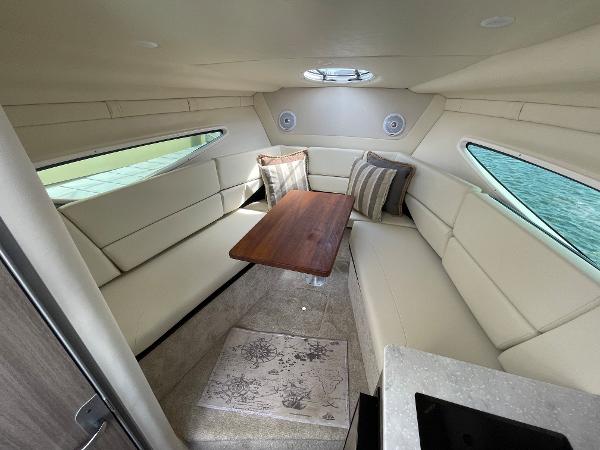 Slide: The Image of Interior of 2021 Regal 26 Express boat with beige seating and wooden table. - 15