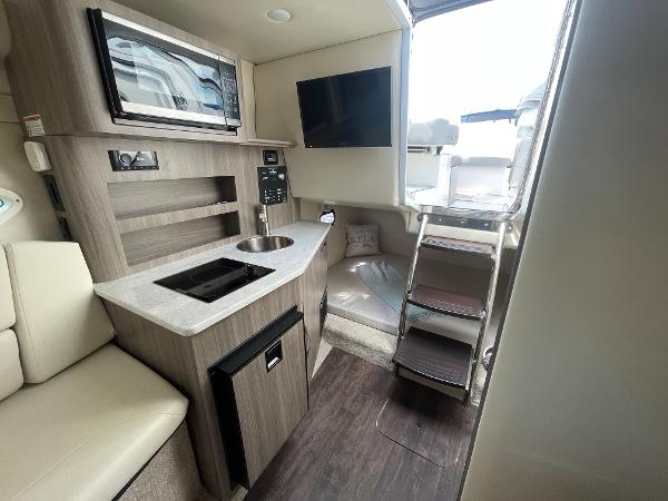 Slide: The Image of 2021 Regal 26 Express cabin interior with kitchenette, seating, and stairs. - 16
