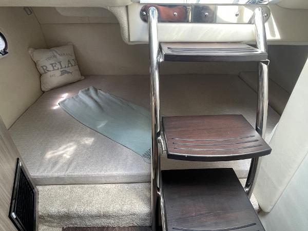 Slide: The Image of Interior cabin of 2021 Regal 26 Express boat with cozy bedding and wooden steps. - 22