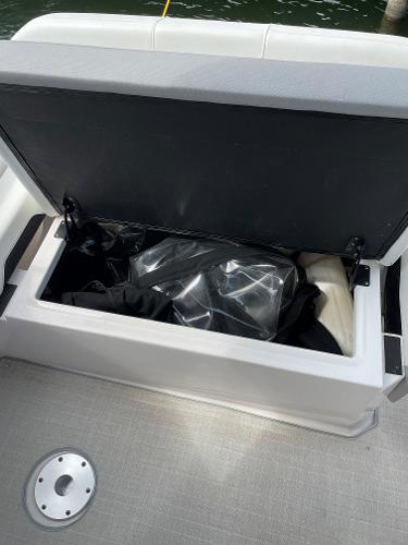 Slide: The Image of Open storage compartment on 2021 Regal 26 Express boat, containing various items. - 30