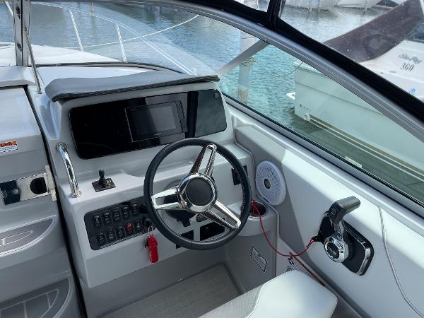 Slide: The Image of Cockpit of 2021 Regal 26 Express boat with steering wheel and control panel. - 9