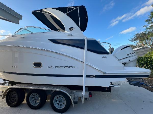 Slide: The Image of 2020 Regal 26 XO boat on trailer with Yamaha engine, parked outdoors. - 1