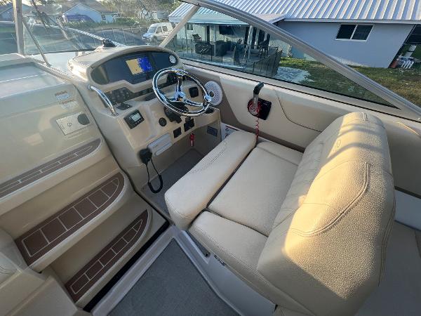 Slide: The Image of 2020 Regal 26 XO boat cockpit with steering wheel and beige seating. - 13