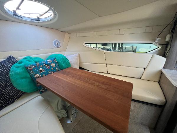 Slide: The Image of Interior of 2020 Regal 26 XO boat with cozy seating and wooden table. - 30