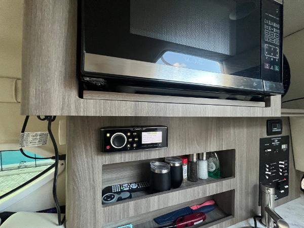 Slide: The Image of 2020 Regal 26 XO boat interior with microwave, control panel, and storage shelves. - 37