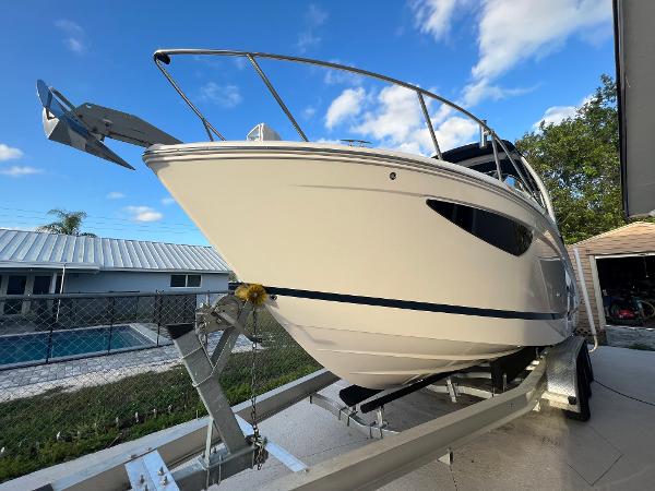 Slide: The Image of 2020 Regal 26 XO boat on trailer, parked outdoors under a clear blue sky. - 4