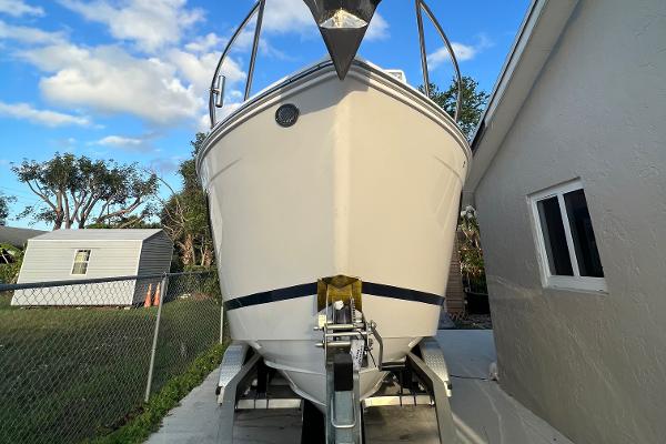 Slide: The Image of 2020 Regal 26 XO boat on trailer, parked beside a house under a clear blue sky. - 7