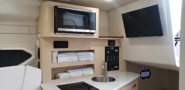Slide: The Image of 2025 Regal 26 XO boat interior with microwave, sink, and TV. - 11