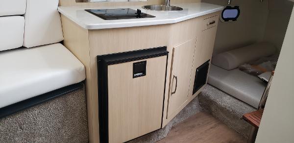 Slide: The Image of 2025 Regal 26 XO boat interior with kitchenette and seating area. - 12