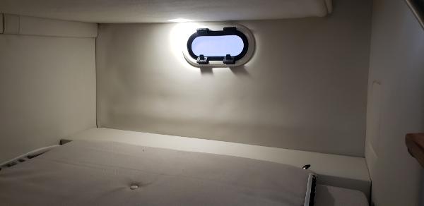 Slide: The Image of 2025 Regal 26 XO cabin interior with a small window and bed. - 14