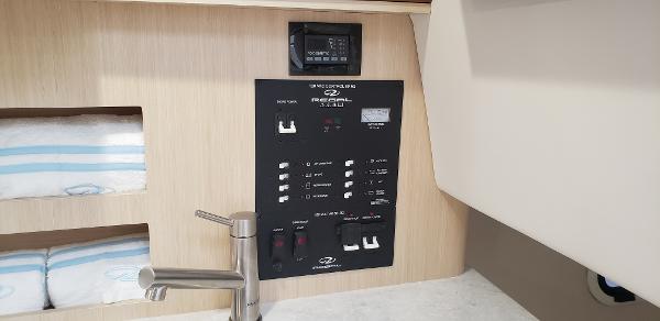 Slide: The Image of 2025 Regal 26 XO boat interior control panel with faucet and storage shelves. - 16