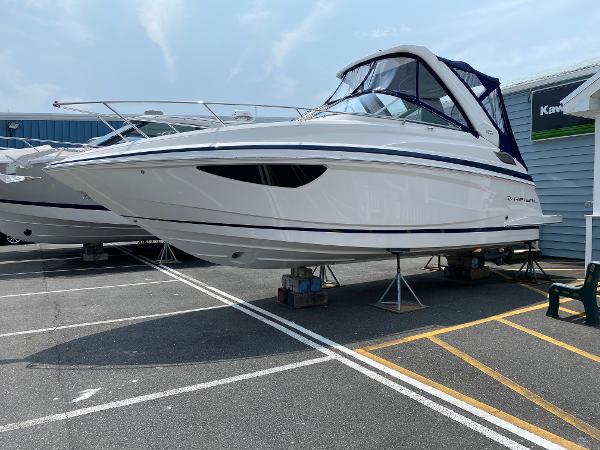 Slide: The Image of 2025 Regal 28 Express boat on display in a marina parking lot. - 0