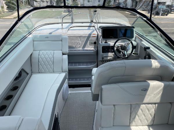 Slide: The Image of Interior of 2025 Regal 28 Express boat with white leather seating and modern dashboard. - 20