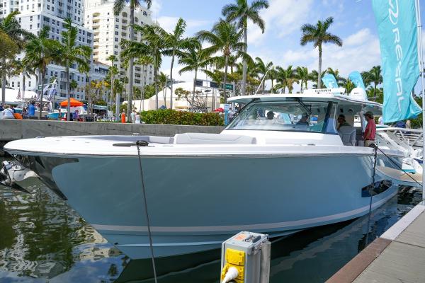 Slide: The Image of 2025 Regal 50 SAV luxury yacht docked at marina with palm trees and buildings in background. - 0
